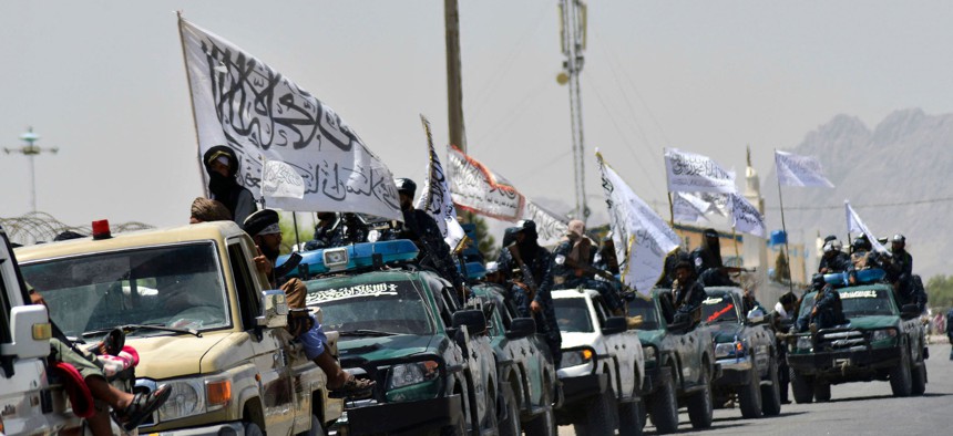 Taliban fighters atop vehicles with Taliban flags parade along a road to celebrate the U.S. pulled all troops out of Afghanistan, in Kandahar, on September 1, 2021.