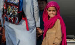 A child waits with her family to board a C-17 Globemaster lll, Aug. 22, 2021, at Al Udeid Air Base, Qatar, after being evacuated from Afghanistan. 