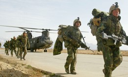 U.S. Army soldiers from the 10th Mountain and the 101st Airborne units disembark from a Chinook helicopter March 11, 2002 as they return to Bagram airbase from the fighting in eastern Afghanistan.