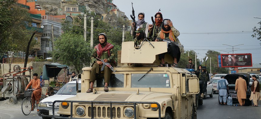 Taliban fighters atop a Humvee vehicle take part in a rally in Kabul on August 31, 2021 