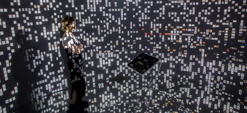 A woman views historical documents and photographs displayed in a high tech art installation at Salt Galata on May 6, 2017 in Istanbul, Turkey.