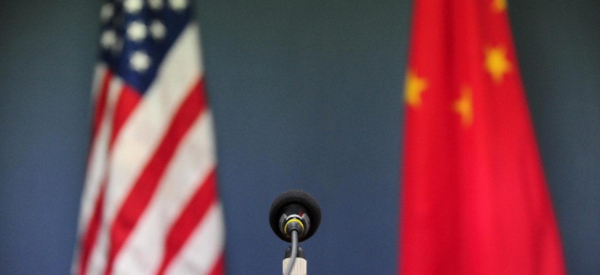The US and China flags stand behind a microphone.
