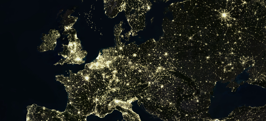 True colour satellite image of Europe at night with country borders.