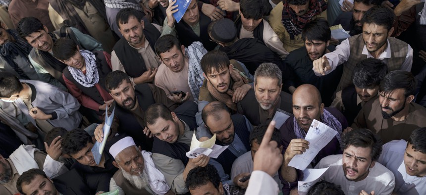 People gather outside a government passport office recently re-opened after Taliban announced they would be issuing a backlog of applications approved by the previous administration in Kabul, Afghanistan, Oct. 6, 2021.