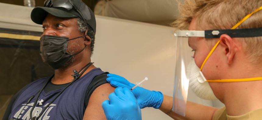 A Norwegian soldier administers the COVID-19 vaccine to a civilian contractor at Al Asad Air Base, Iraq, on June 4, 2021.