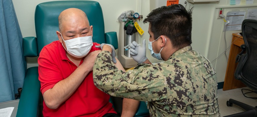 Hospital Corpsman 2nd Class Mark Perez  administers the first dose of the Moderna COVID-19 vaccine to a Master Laborer Contractor employed onboard Naval Air Facility Atsugi June 18. 