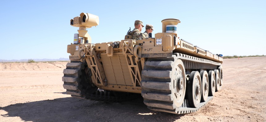 The expeditionary modular autonomous vehicle is prepared to transport a load of supplies as a training exercise in preparation for Project Convergence at Yuma Proving Ground, Ariz. October 19, 2021. 