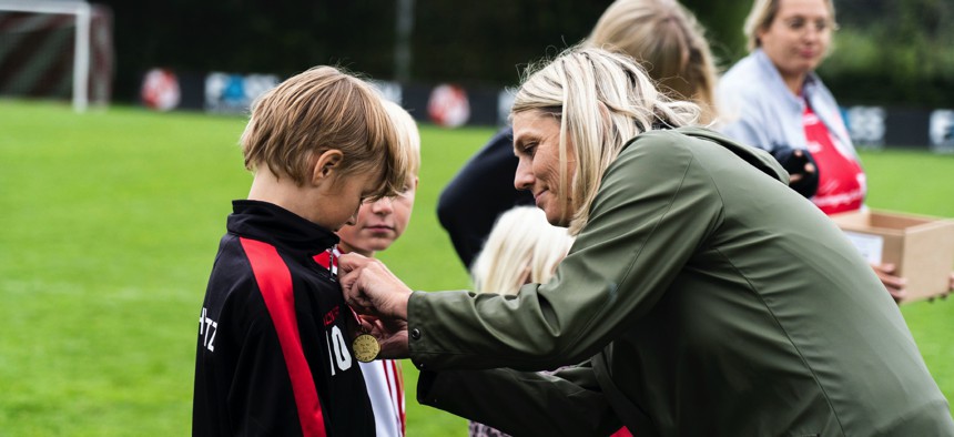 Defense Minister Trine Bramsen pins medals on children of Danish veterans.