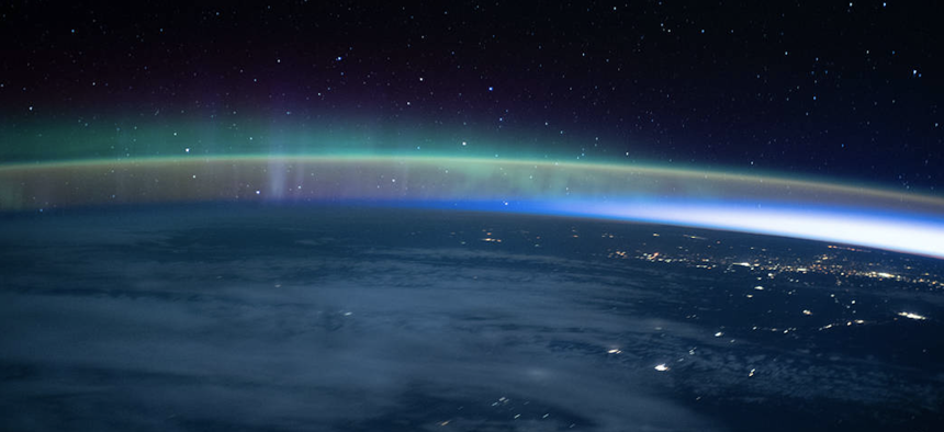 In this image taken on Oct. 30, 2021, an aurora dimly intersected with Earth's airglow as the International Space Station flew into an orbital sunrise above the Pacific Ocean.