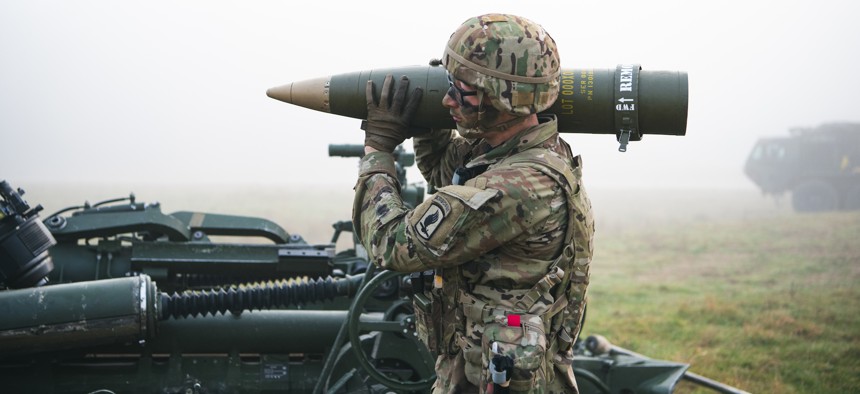A U.S. Army paratrooper shoulders a round for the M777 Howitzer for an artillery fire capabilities demonstration, Oct. 18, 2021. A spike in inflation has Pentagon officials bracing for more expensive weapons in the years to come.