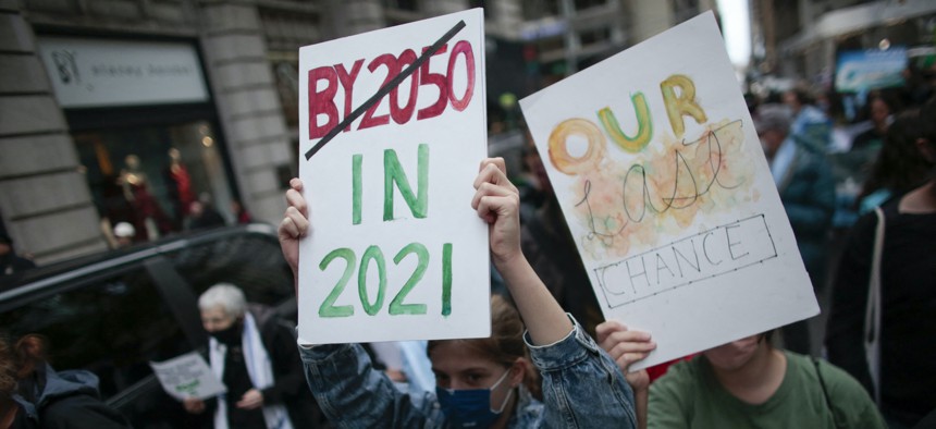 Protestors hold signs during the Climate Justice March in New York on November 13, 2021.