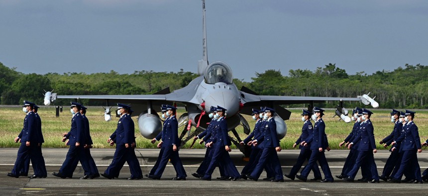 Taiwan Air Force staffers walk pass an upgraded US-made F-16 V fighter during a ceremony at the Chiayi Air Force in southern Taiwan on November 18, 2021.