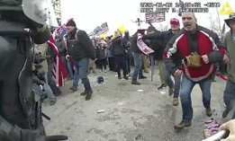 This still frame from Metropolitan Police Department body-worn camera video shows Thomas Webster, in red jacket, at a barricade line at on the west front of the U.S. Capitol on Jan. 6, 2021, in Washington. Webster, a Marine Corps veteran and retired New York City Police Department Officer, is accused of assaulting an MPD officer with a flagpole. 