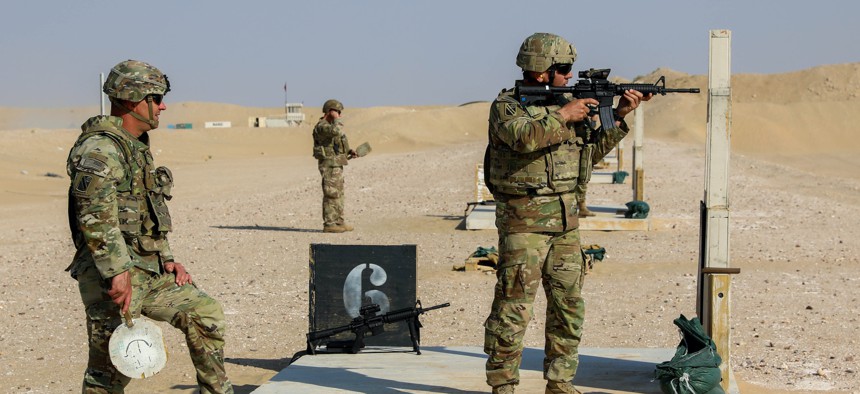 U.S. Army National Guard Capt. Joshua Cobb, assigned to Headquarters and Headquarters Battery, Task Force Iron Valor, spots for Capt. Nathan Davis, assigned to Bravo Battery, TF Iron Valor, as he shoots during his individual weapon qualification at Udari Range Complex, Kuwait on October 26, 2021.