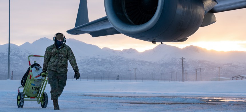 U.S. Air Force Senior Airman Oscar Oliver, a 703d Aircraft Maintenance Squadron crew chief, pulls a fire-suppression bottle at Joint Base Elmendorf-Richardson, Alaska, Dec. 2, 2021.