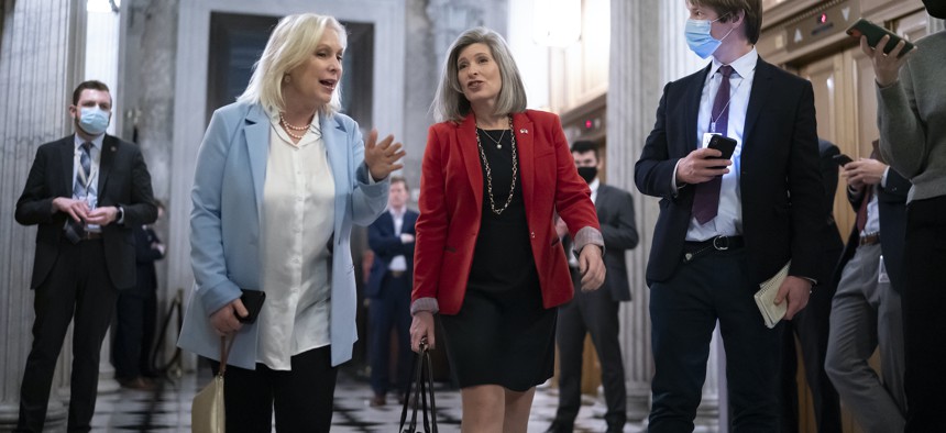 Sen. Kirsten Gillibrand, D-N.Y., left, and Sen. Joni Ernst, R-Iowa, who worked together on legislation to reform the military justice system, arrive for a Senate vote on a different issue Dec. 2, 2021.