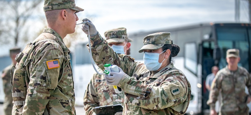 A new recruit gets his temperature taken at Fort Sill, Okla., April 7, 2020.