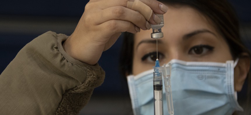 An airman prepares a syringe before administering a COVID-19 vaccination at Barksdale Air Force Base, La., Nov. 7, 2021.