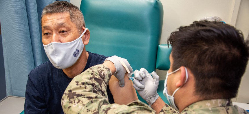 Navy Petty Officer 2nd Class Mark Perez administers the first dose of the Moderna COVID-19 vaccine to a master laborer contractor at Naval Air Facility Atsugi, Japan, June 18, 2021. 