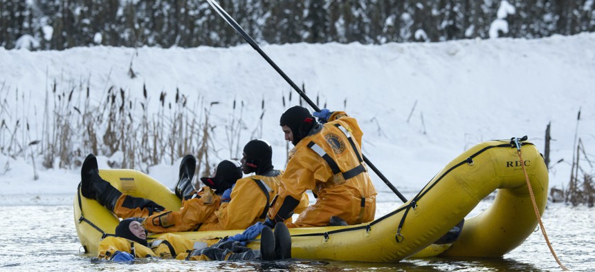 U.S. Air Force fire protection specialists use an inflatable raft while conducting ice rescue training at Six Mile Lake on Joint Base Elmendorf-Richardson, Alaska, Dec. 29, 2021.