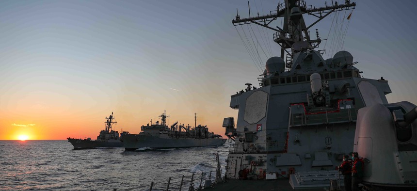 The Arleigh Burke-class guided-missile destroyer USS Ross, right, breaks away from the fast combat support ship USNS Supply, center, as it continues a replenishment-at-sea with USS Roosevelt, Jan. 2, 2022. 