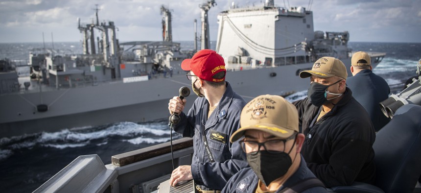 Cmdr. Jermaine Brooms, right, commanding officer of the Arleigh Burke-class guided-missile destroyer USS Dewey, Cmdr. Nick Hoffman, executive officer, and Lt.j.g. Colin Dablain supervise maneuvering from the bridge wing during a replenishment-at-sea with the Japan Maritime Self-Defense Force replenishment ship JS Oumi. 