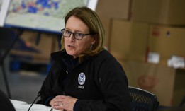 FEMA Administrator Deanne Criswell speaks as President Biden listens during a briefing on tornado devastation, at Mayfield Graves County Airport, in Mayfield, Kentucky, on December 15, 2021.