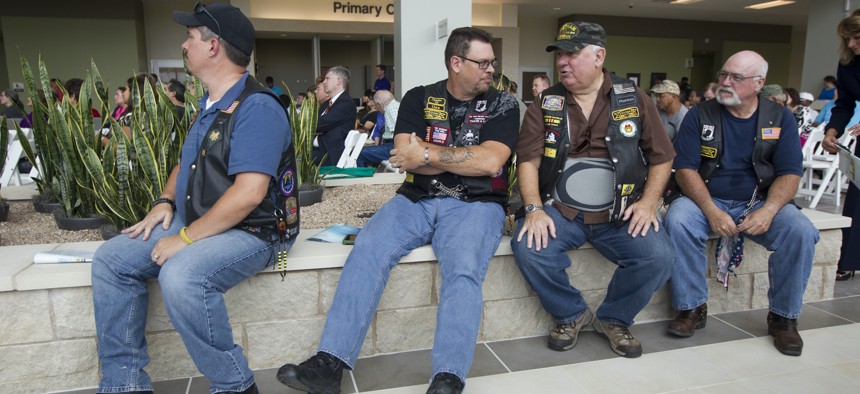 U.S. military veterans wait in the lobby area during the grand opening of a new Veteran's Administration VA Outpatient Clinic in southeast Austin, Texas, in 2013.