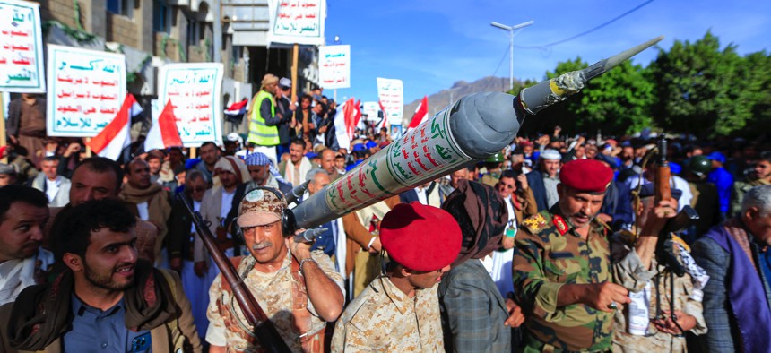 Supporters of Yemen's Houthi rebel movement carry a mock rocket as they demonstrate in the capital Sanaa to denounce a reported air strike by the Saudi-led coalition on a prison in the country's rebel-held north on January 21, 2022.