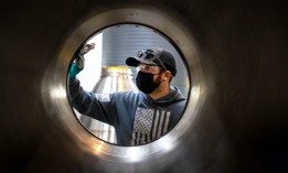 Chase Wallace, a metal fitter, dusts off a RS-25 rocket engine nozzle in preparation for brazing at Aerojet Rocketdyne in Canoga Park on Tuesday, September 28, 2021.