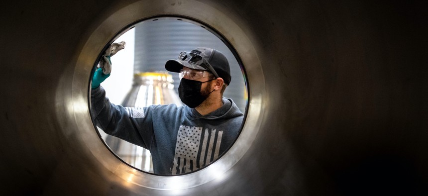 Chase Wallace, a metal fitter, dusts off a RS-25 rocket engine nozzle in preparation for brazing at Aerojet Rocketdyne in Canoga Park on Tuesday, September 28, 2021.