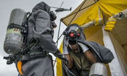 Pfc. Khalid Harrison, a U.S. Army soldier with the 51st Chemical Biological Radiological Nuclear Company, of Fort Stewart, Georgia, removes his chemical suit for decontamination during a training exercise at the Muscatatuck Urban Training Center, Indiana, April 27, 2017.