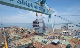 The island of the aircraft carrier USS John F. Kennedy (CVN 79) is landed onto the flight deck during a mast-stepping ceremony at Huntington Ingalls Industries Newport News Shipbuilding in Newport News, Va., May 29, 2019. 