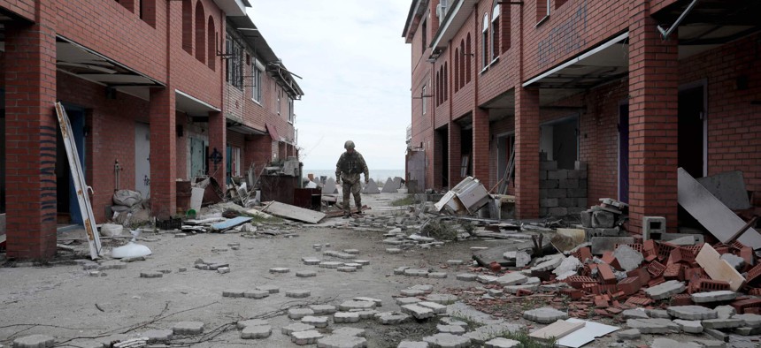 An Ukrainian serviceman walks past destroyed buildings in the village of Shyrokyne near Mariupol, the last large city in eastern Ukraine controlled by Kiev.