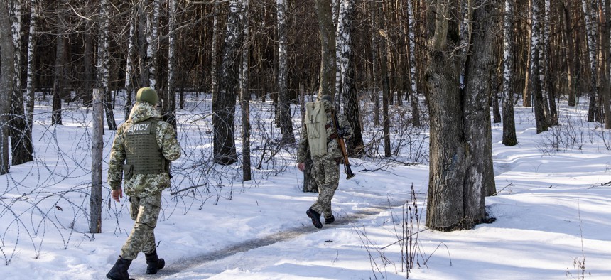 Members of the Ukrainian Border Guard patrol along the Ukrainian border fence at the Three Sisters border crossing between, Ukraine, Russia and Belarus on February 14, 2022 in Senkivka, Ukraine.