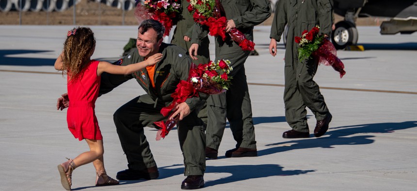 Cmdr. Mark Cochran, left, commanding officer of Strike Fighter Squadron (VFA) 147, is welcomed home by family at Naval Air Station Lemoore, Calif. VFA-147, as part of Carl Vinson Carrier Strike Group and Carrier Air Wing 2, returned home following an eight-month deployment.