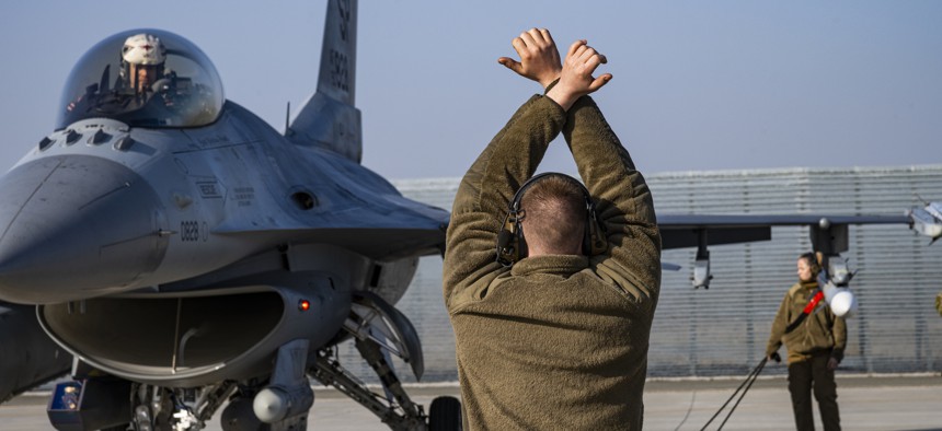 U.S. Air Force Airman 1st Class Alex Coloumbe, 480th Expeditionary Fighter Squadron dedicated crew chief, marshals an F-16 Fighting Falcon aircraft assigned to the 480th FS at Spangdahlem Air Base, Germany, at the 86th Air Base, Romania, Feb. 17, 2022.
