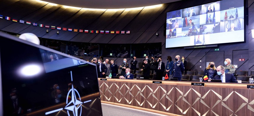 NATO leaders (seen on screen) attend a video summit on Russia's invasion of the Ukraine at the NATO headquarters in Brussels on February 25, 2022.