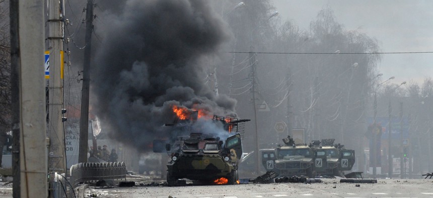 This photograph taken on February 26, 2022 shows a Russian Armoured personnel carrier (APC) burning during fight with the Ukrainian armed forces in Kharkiv.