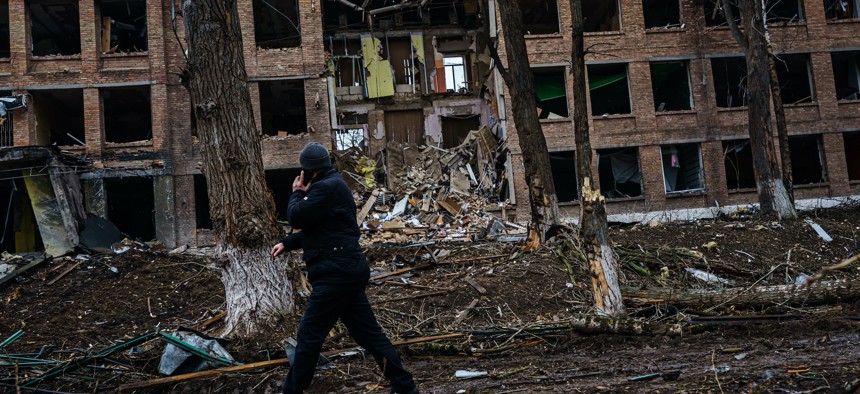 A man walks past a building damaged by Russian airstrikes in Vasylkiv, Ukraine, Wednesday, March 2, 2022.