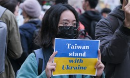 A protester holds a placard expressing her opinion, during a demonstration against Russia's military invasion on Ukraine. 