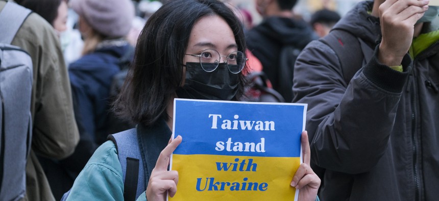 A protester holds a placard expressing her opinion, during a demonstration against Russia's military invasion on Ukraine. 