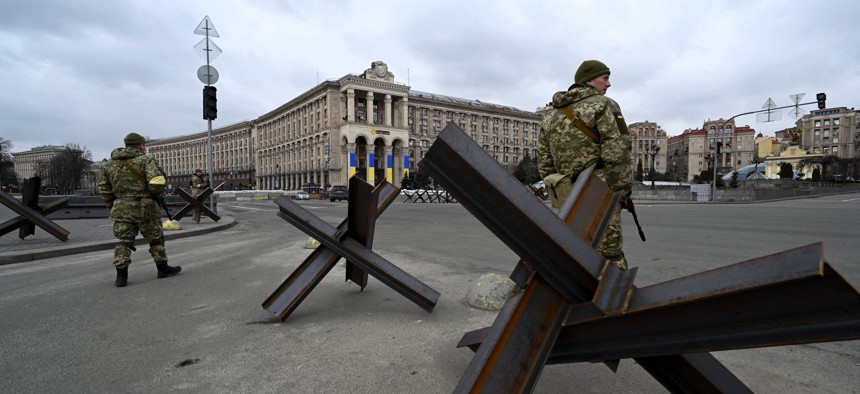Members of the Ukrainian Territorial Defence Forces, the military reserve of the Ukrainian Armed Forces, stand guard next to anti-tank structures blocking the streets of the center of Kyiv on March 6, 2022. 
