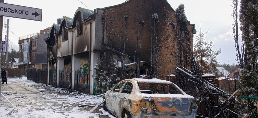  A burnt-out car and houses caused by the Russian military attack.