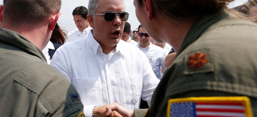 Colombian President Ivan Duque greets U.S. military personnel and a C-17 cargo plane loaded with food, water, and medicine for a humanitarian mission to aid Venezuelans after it landed in Cucuta, Colombia, on February 22, 2019.