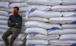 A worker sits next to a pile of flour sacks in Baghdad, Iraq, where wheat prices have surged after the Russian invasion of Ukraine. 