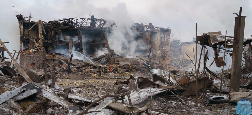 Firefighters spray water on a destroyed shoe factory following an airstrike in Dnipro, Ukraine, on March 11, 2022. 