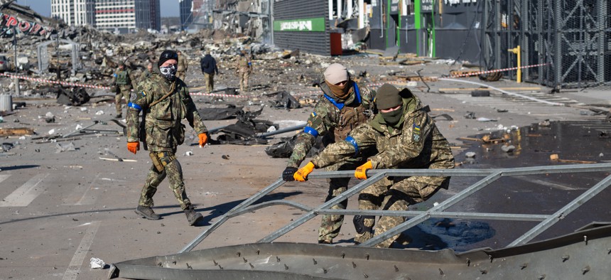 Ukrainian servicemen examine damage from a Russian air strike on a shopping mall in Kyiv, Ukraine, March 21, 2022.