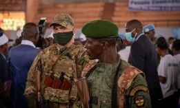A private security guard from the Russian group Wagner (L) stands next to a Central African Republic soldier during a rally of the United Hearts Movement (MCU) political party at the Omnisport Stadium in Bangui on March 18, 2022.