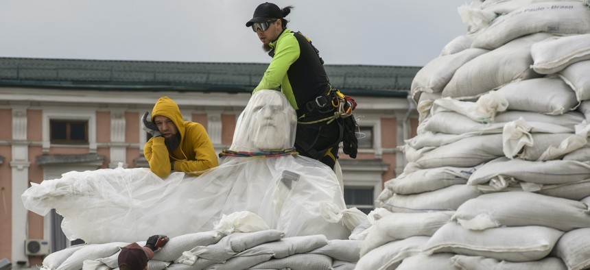 Volunteers cover a monument of the Princess Olga, Apostle Andrew, Cyril, and Methodius of sand bags for protection as Russia's invasion of Ukraine continues, in historical center of Kyiv, Ukraine, March 29, 2022.